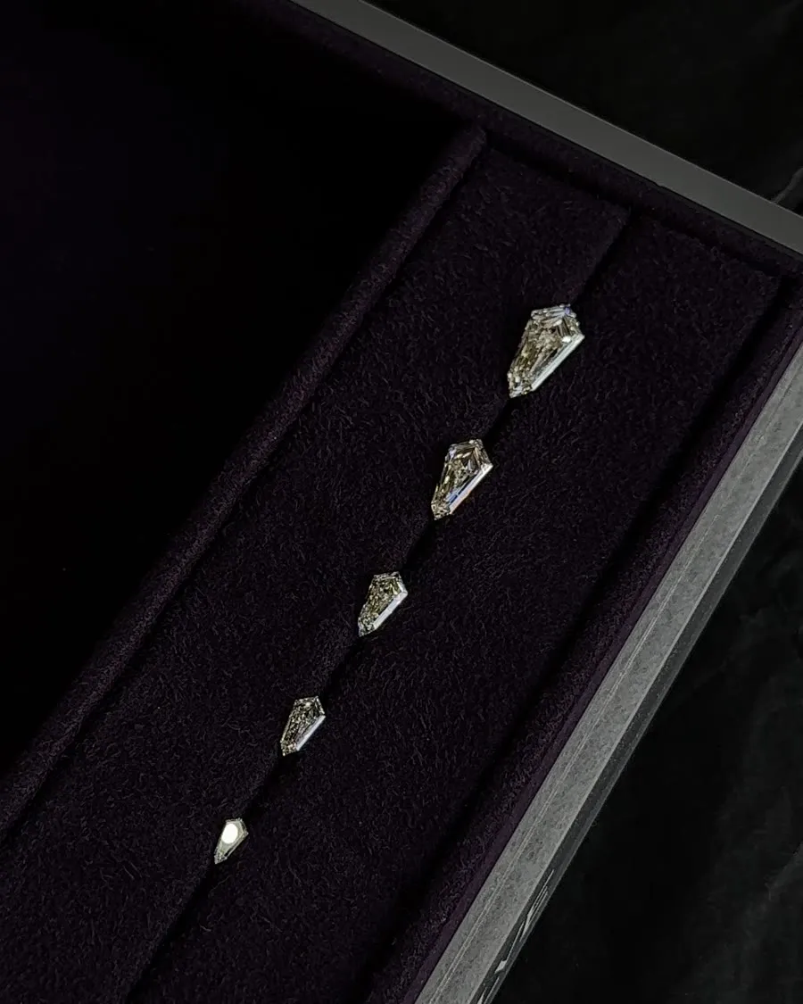Kite-cut diamonds set out in a line on a deep purple tray